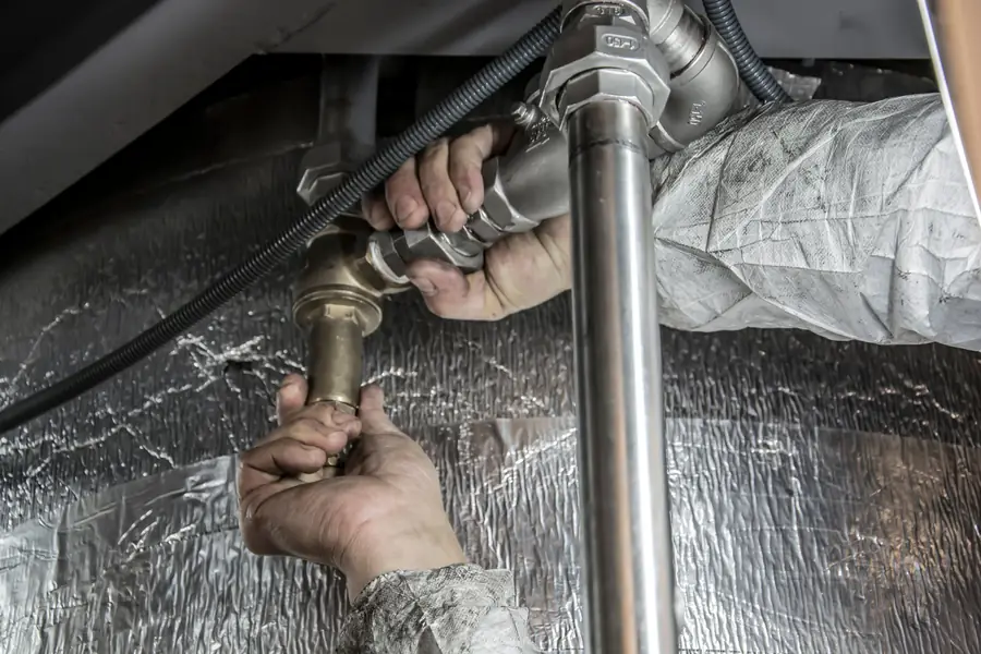 Plumber tightening a fitting on an insulated water line