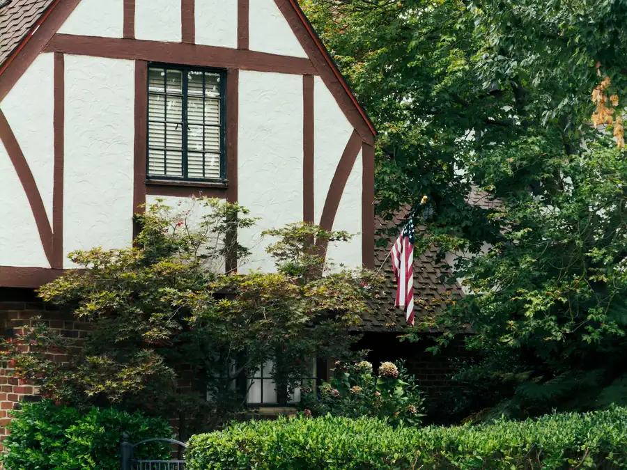 Tudor style brick house with a steep gable and hedges